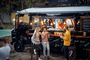 People enjoying food outside of a food truck
