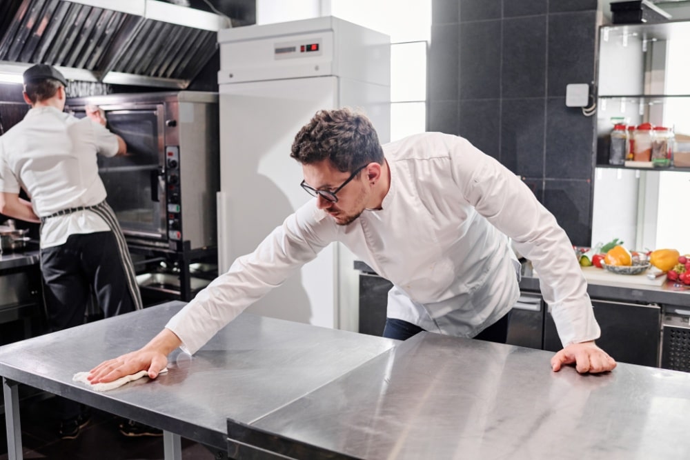 a staff cleaning the restaurant's kitchen